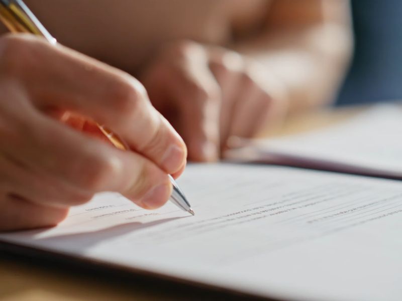 osoba potpisuje dokumente